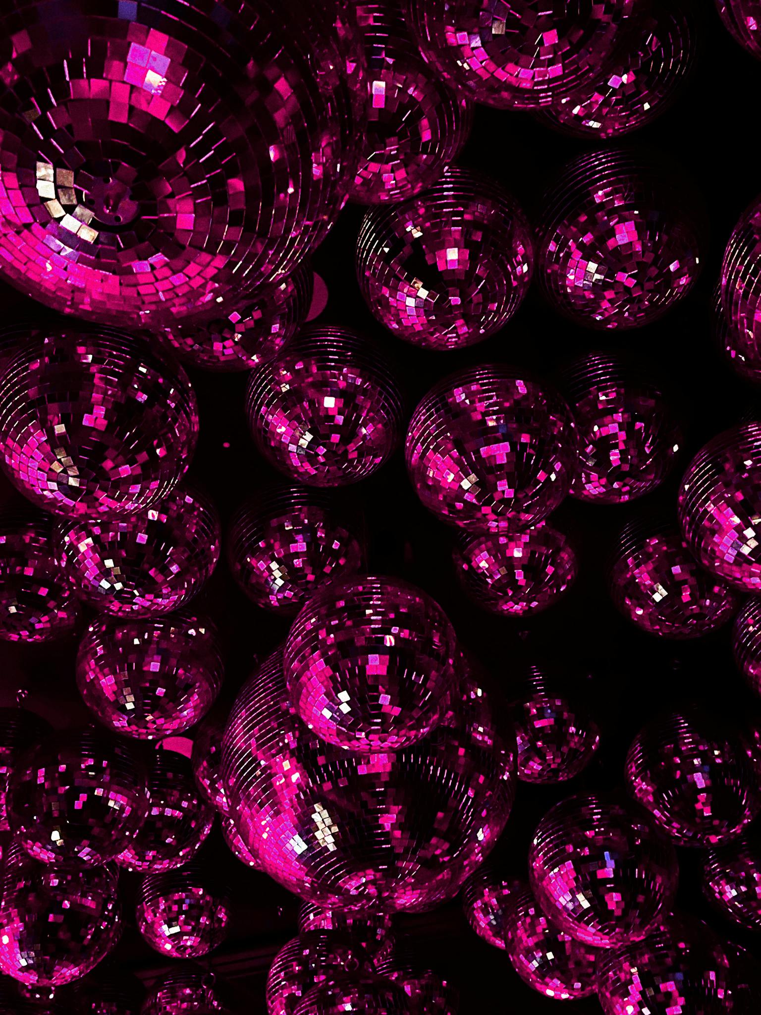 Glamorous disco balls in pink create a dazzling atmosphere for any nightlife event.