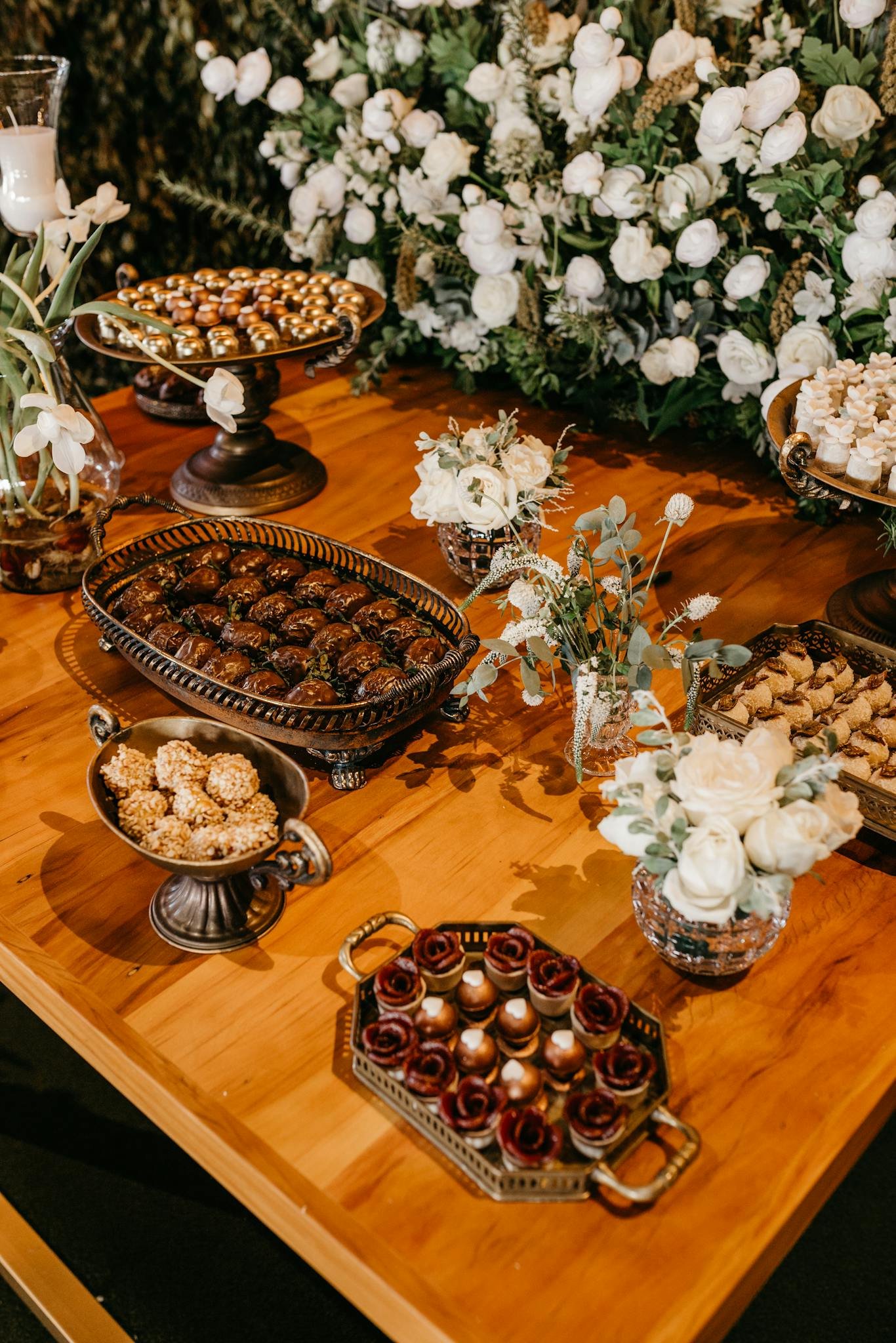 Luxurious assortment of desserts on a vintage table setting with beautiful floral decor.