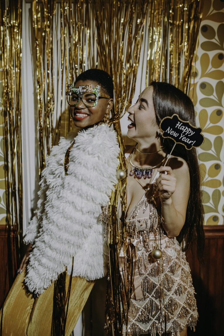Vibrant New Year's Eve party with joyful friends in glamorous attire posing for fun photos.